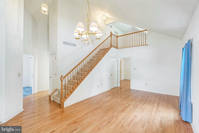 22 Regents Ct, Bensalem, PA 19020 - unfurnished living room featuring high vaulted ceiling, stairs, wood finished floors, a chandelier, and baseboards
