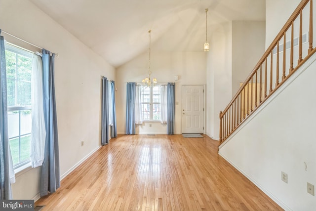 22 Regents Ct, Bensalem, PA 19020 - unfurnished living room with plenty of natural light, a chandelier, stairway, light wood-type flooring, and high vaulted ceiling