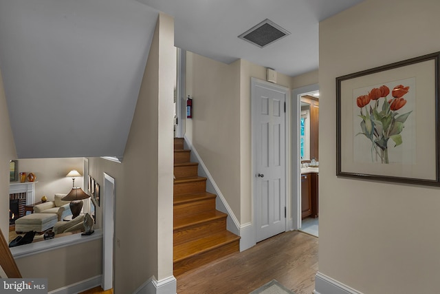 410 Heatherwood Ln, Devon, PA 19333 - staircase featuring wood finished floors, a fireplace, and baseboards