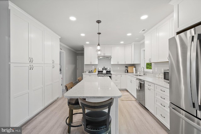 36032 Double Bridges Rd, Frankford, DE 19945 - kitchen with appliances with stainless steel finishes, crown molding, under cabinet range hood, a kitchen island, and white cabinetry