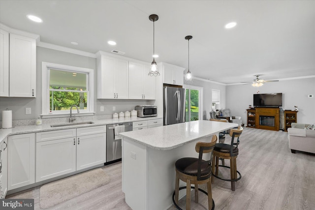 36032 Double Bridges Rd, Frankford, DE 19945 - kitchen with appliances with stainless steel finishes, ornamental molding, open floor plan, white cabinets, and a center island