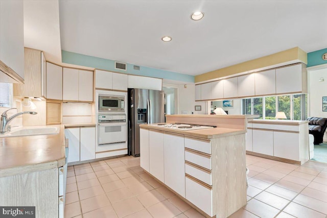 3 White Horse Ln, Spring City, PA 19475 - kitchen with stainless steel appliances, a sink, light countertops, light tile patterned floors, and a kitchen island