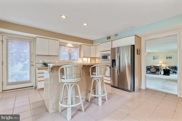 3 White Horse Ln, Spring City, PA 19475 - kitchen featuring appliances with stainless steel finishes, a breakfast bar, light countertops, light tile patterned floors, and recessed lighting