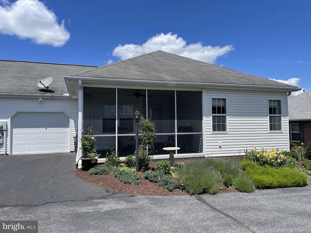 18 Brethren Ct, Gettysburg, PA 17325 - view of front facade featuring a garage, a sunroom, roof with shingles, asphalt driveway, and a ceiling fan