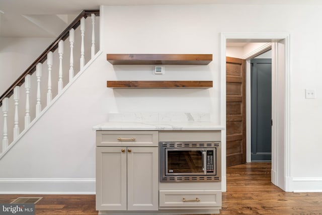 2304 W 19th St, Wilmington, DE 19806 - bar with stainless steel microwave, wood finished floors, stairway, and baseboards