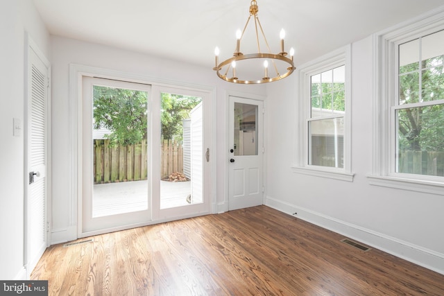 2304 W 19th St, Wilmington, DE 19806 - unfurnished dining area featuring a chandelier, baseboards, and wood finished floors