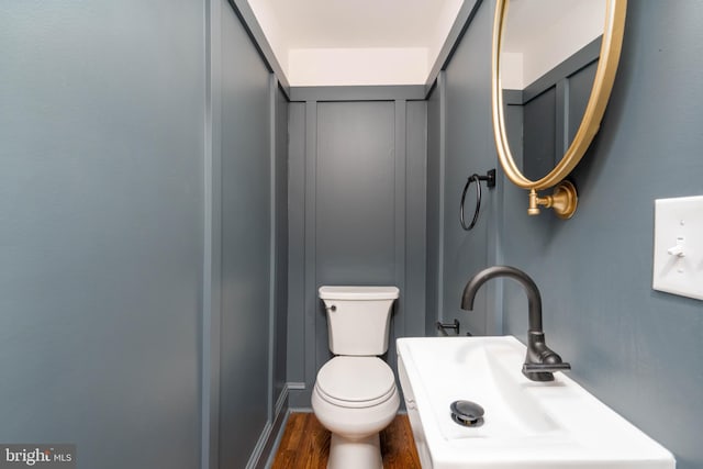 2304 W 19th St, Wilmington, DE 19806 - half bathroom with a sink, toilet, and wood finished floors