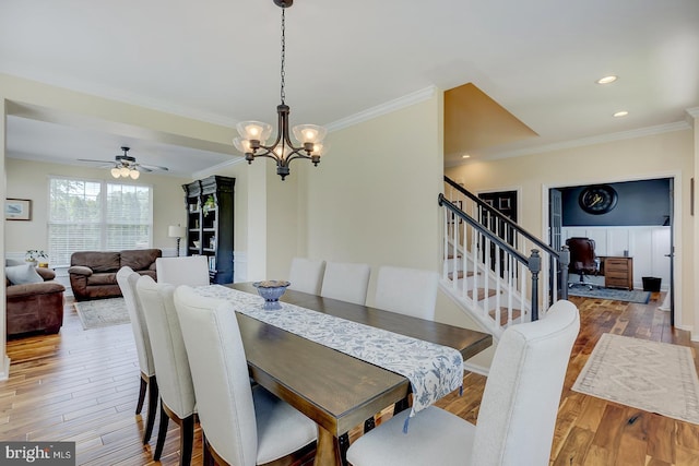 229 Lakshman Trl, Dover, DE 19904 - dining space featuring ornamental molding, wood finished floors, a chandelier, a ceiling fan, and stairs