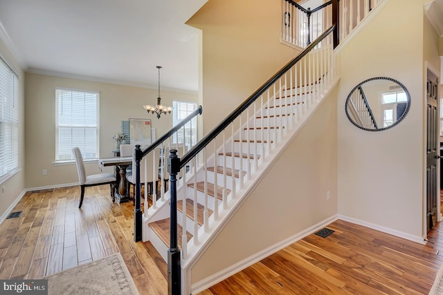 229 Lakshman Trl, Dover, DE 19904 - staircase with a chandelier, ornamental molding, wood finished floors, and baseboards