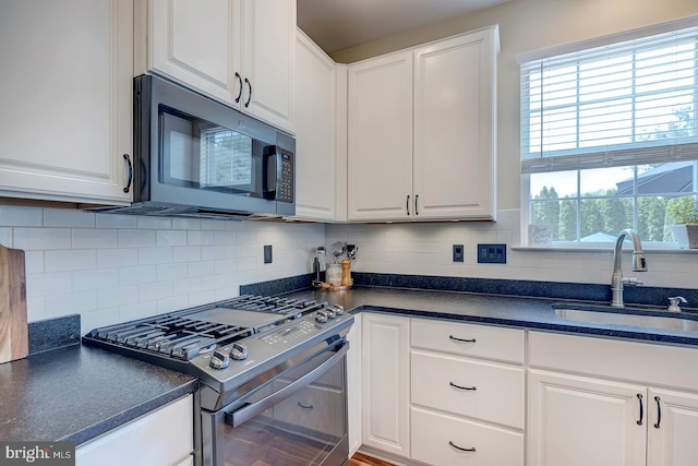 229 Lakshman Trl, Dover, DE 19904 - kitchen with black microwave, stainless steel range with gas cooktop, a sink, dark countertops, and white cabinets