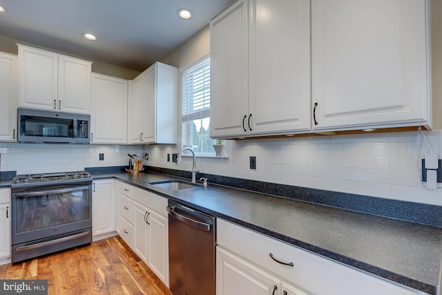 229 Lakshman Trl, Dover, DE 19904 - kitchen featuring stainless steel appliances, a sink, dark countertops, white cabinetry, and recessed lighting
