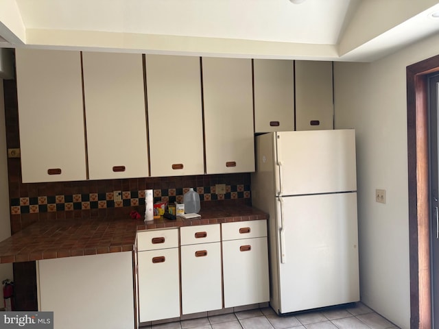 914 Fernon St, Philadelphia, PA 19148 - kitchen with freestanding refrigerator, tile countertops, backsplash, and light tile patterned floors