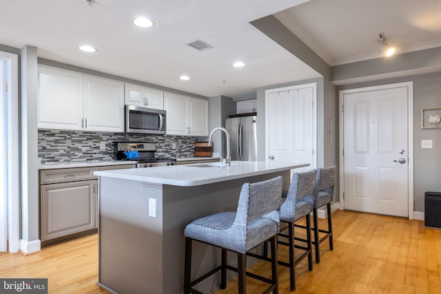 1201 N Garfield St Unit 604, Arlington, VA 22201 - kitchen featuring appliances with stainless steel finishes, a sink, crown molding, decorative backsplash, and a kitchen bar