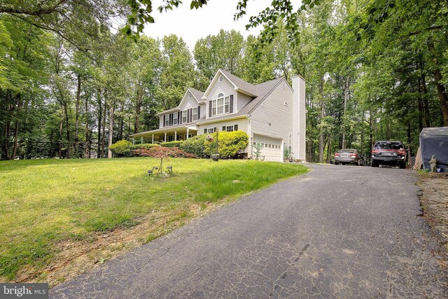 600 Small Reward Rd, Huntingtown, MD 20639 - view of front of house with an attached garage, a front lawn, a chimney, asphalt driveway, and view of scattered trees