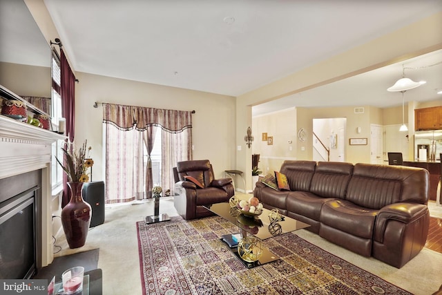 3441 Eagle Ridge Dr, Woodbridge, VA 22191 - carpeted living area with a glass covered fireplace, stairs, and plenty of natural light