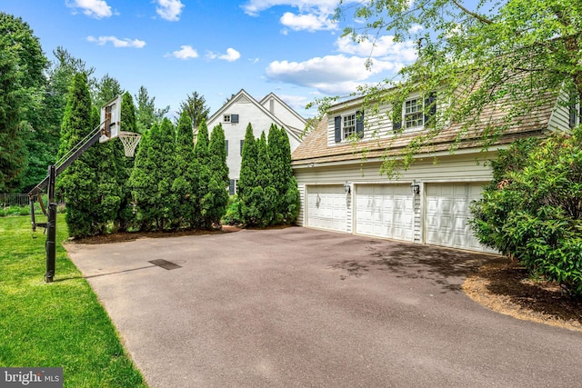 1298 Farm Ln, Berwyn, PA 19312 - view of side of property featuring asphalt driveway, an attached garage, and a yard