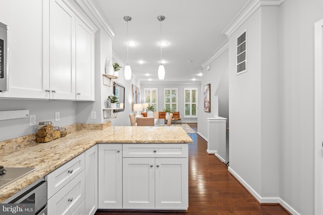 331 K St SE, Washington, DC 20003 - kitchen with dark wood-style flooring, a peninsula, white cabinetry, crown molding, and light stone countertops