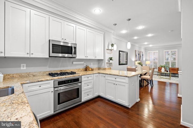 331 K St SE, Washington, DC 20003 - kitchen with stainless steel appliances, crown molding, a peninsula, white cabinets, and dark wood-style flooring