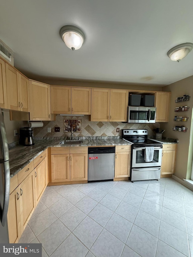 128 Roberts Ln Unit 100, Alexandria, VA 22314 - kitchen featuring stainless steel appliances, light brown cabinetry, a sink, light tile patterned floors, and backsplash