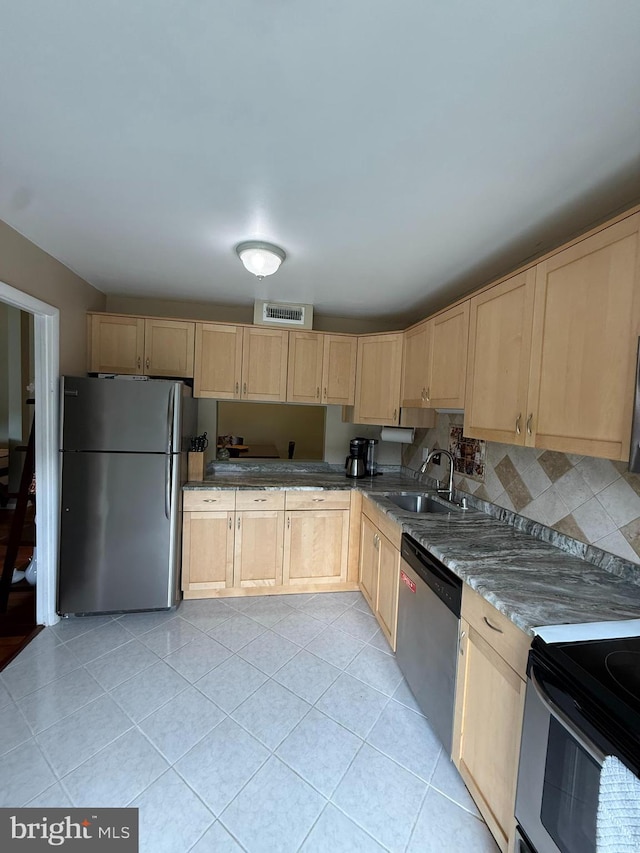 128 Roberts Ln Unit 100, Alexandria, VA 22314 - kitchen with appliances with stainless steel finishes, light brown cabinets, a sink, light tile patterned flooring, and backsplash