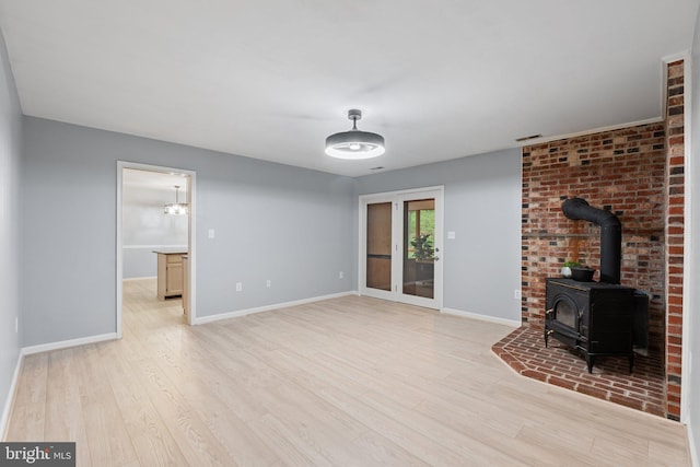 1420 Fishel Rd, Winchester, VA 22602 - unfurnished living room with a wood stove, light wood finished floors, and baseboards