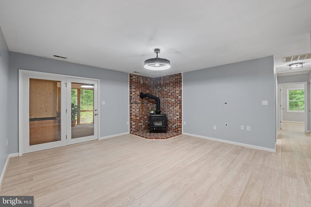1420 Fishel Rd, Winchester, VA 22602 - unfurnished living room with a wood stove, light wood finished floors, and baseboards