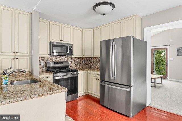 808 Scotia Rd, Philadelphia, PA 19128 - kitchen with cream cabinets, stainless steel appliances, a sink, and decorative backsplash