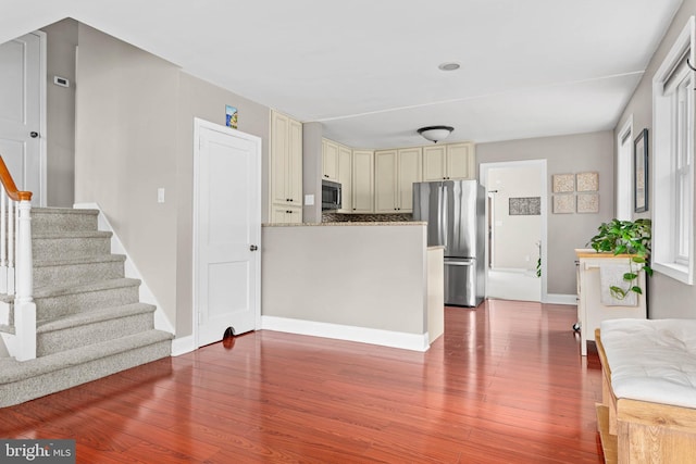 808 Scotia Rd, Philadelphia, PA 19128 - kitchen featuring stainless steel appliances, cream cabinets, wood finished floors, a peninsula, and baseboards
