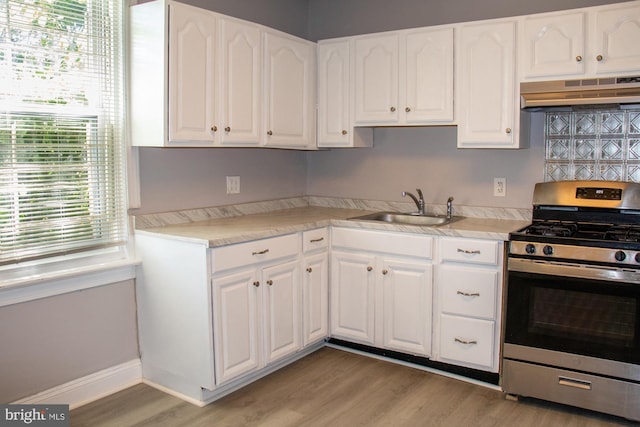 229 New Trent, Ewing, NJ 08638 - kitchen with stainless steel range with gas cooktop, under cabinet range hood, a sink, light wood-style flooring, and white cabinets