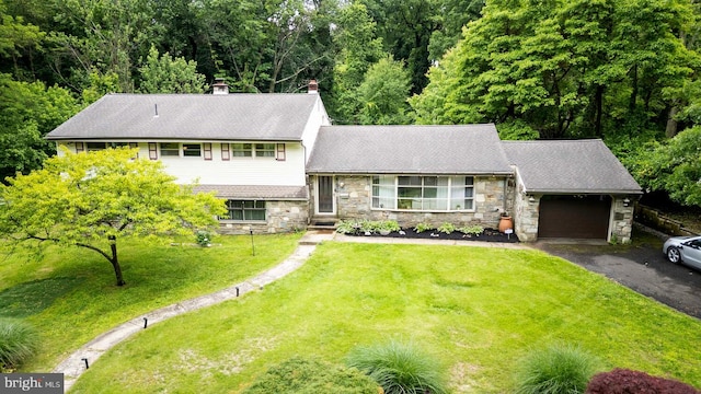 1030 Rock Creek Dr, Wyncote, PA 19095 - split level home featuring an attached garage, stone siding, asphalt driveway, a front lawn, and a chimney