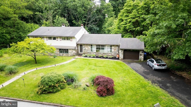 1030 Rock Creek Dr, Wyncote, PA 19095 - tri-level home with stone siding, a garage, driveway, a chimney, and a front yard