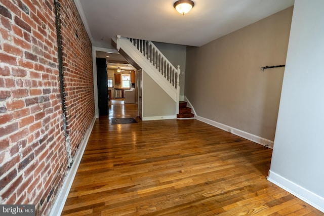 846 W 34th St W, Baltimore, MD 21211 - foyer with stairs, wood finished floors, baseboards, and brick wall