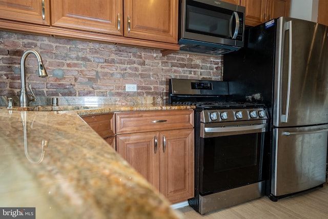 846 W 34th St W, Baltimore, MD 21211 - kitchen featuring appliances with stainless steel finishes, tasteful backsplash, a sink, brown cabinets, and light stone countertops