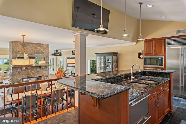 22 E Lake Dr, Annapolis, MD 21403 - kitchen featuring a sink, built in appliances, crown molding, dark stone counters, and a kitchen island with sink