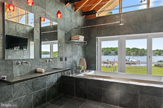 22 E Lake Dr, Annapolis, MD 21403 - full bath with healthy amount of natural light, tiled tub, a water view, and high vaulted ceiling