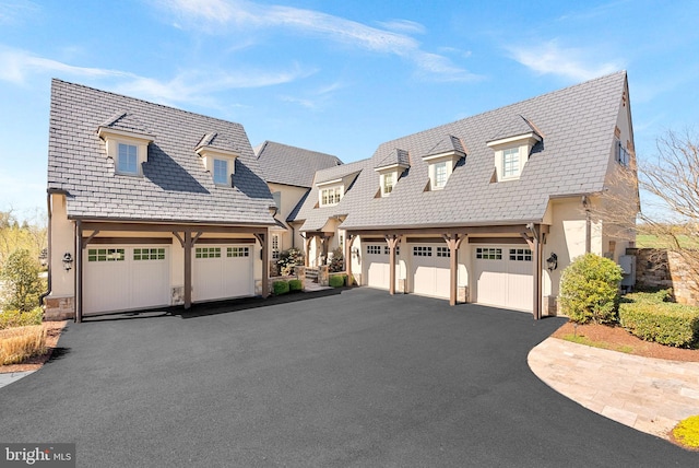 22701 Creighton Farms Dr, Leesburg, VA 20175 - view of front of house featuring driveway, stucco siding, stone siding, and a garage
