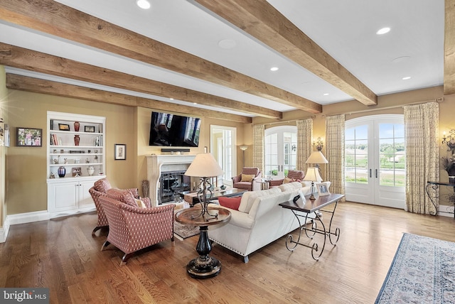 22701 Creighton Farms Dr, Leesburg, VA 20175 - living room with beamed ceiling, french doors, a glass covered fireplace, wood finished floors, and recessed lighting