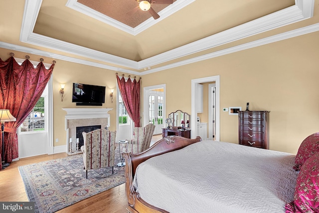 22701 Creighton Farms Dr, Leesburg, VA 20175 - bedroom featuring a tray ceiling, wood finished floors, a fireplace, and crown molding