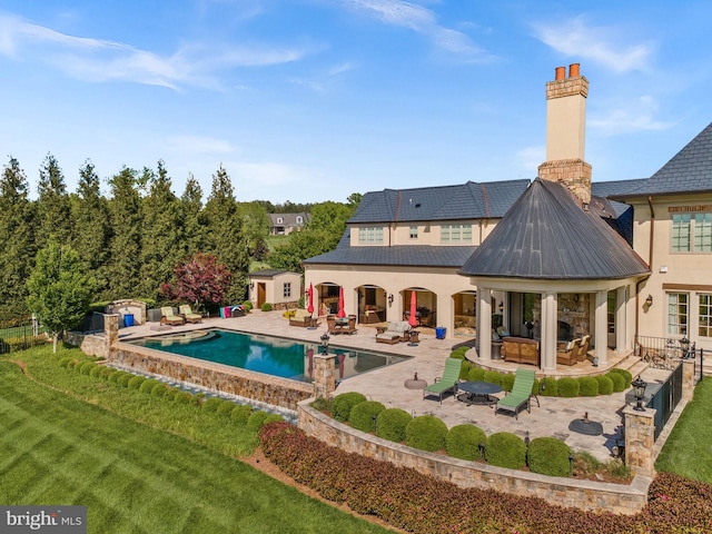 22701 Creighton Farms Dr, Leesburg, VA 20175 - rear view of house with an outdoor living space, a patio, stucco siding, and a chimney