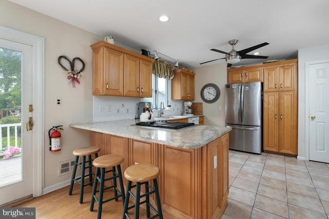 100 Weldon Way, Pennington, NJ 08534 - kitchen with appliances with stainless steel finishes, a peninsula, light stone counters, a kitchen bar, and ceiling fan
