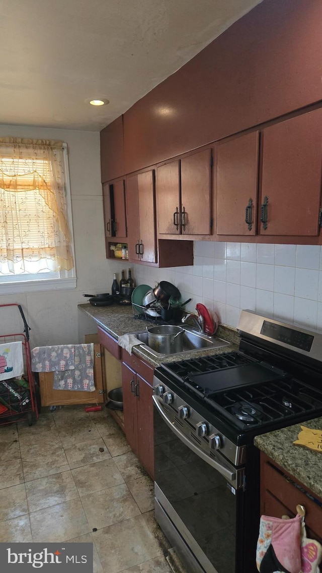 4932 Gransback St, Philadelphia, PA 19120 - kitchen with stainless steel gas stove, decorative backsplash, and a sink