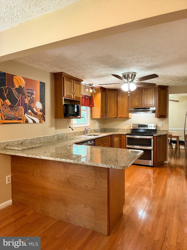 8017 Cipher Row, Jessup, MD 20794 - kitchen featuring double oven range, black microwave, a textured ceiling, under cabinet range hood, and brown cabinetry