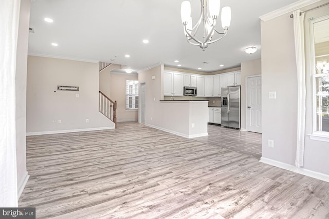 43415 Madison Renee Ter Unit 120, Ashburn, VA 20147 - kitchen with appliances with stainless steel finishes, open floor plan, light wood-style flooring, ornamental molding, and baseboards