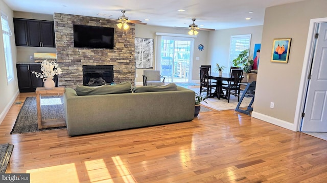 4001 7th St, North Beach, MD 20714 - living room featuring a ceiling fan, a stone fireplace, light wood-type flooring, baseboards, and recessed lighting