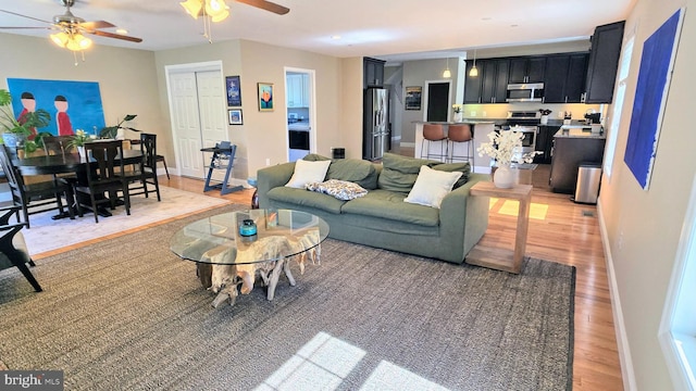 4001 7th St, North Beach, MD 20714 - living area featuring a ceiling fan, light wood finished floors, and baseboards