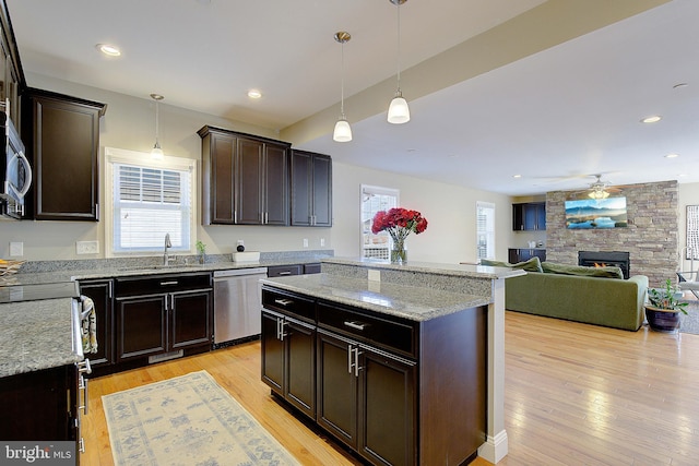 4001 7th St, North Beach, MD 20714 - kitchen featuring dishwasher, a sink, a center island, light wood finished floors, and a fireplace