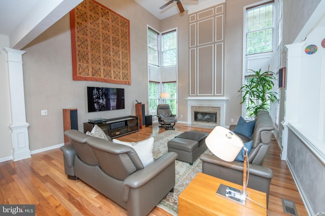 32 Eagleton Farm Rd, Newtown, PA 18940 - living room with ornate columns, a fireplace, a towering ceiling, light wood-type flooring, and ceiling fan