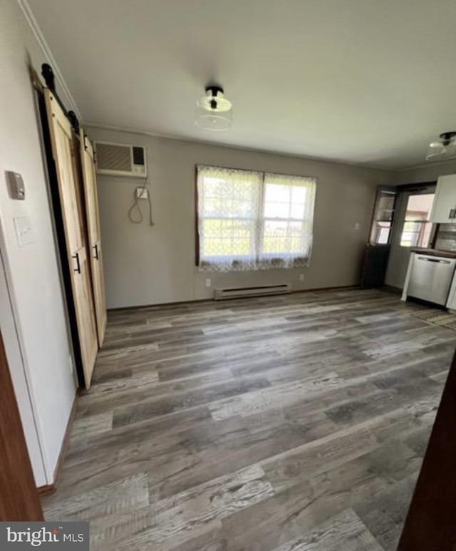 230 Eisenhower Dr, Orwigsburg, PA 17961 - unfurnished living room with a barn door, a wall unit AC, wood finished floors, baseboard heating, and crown molding