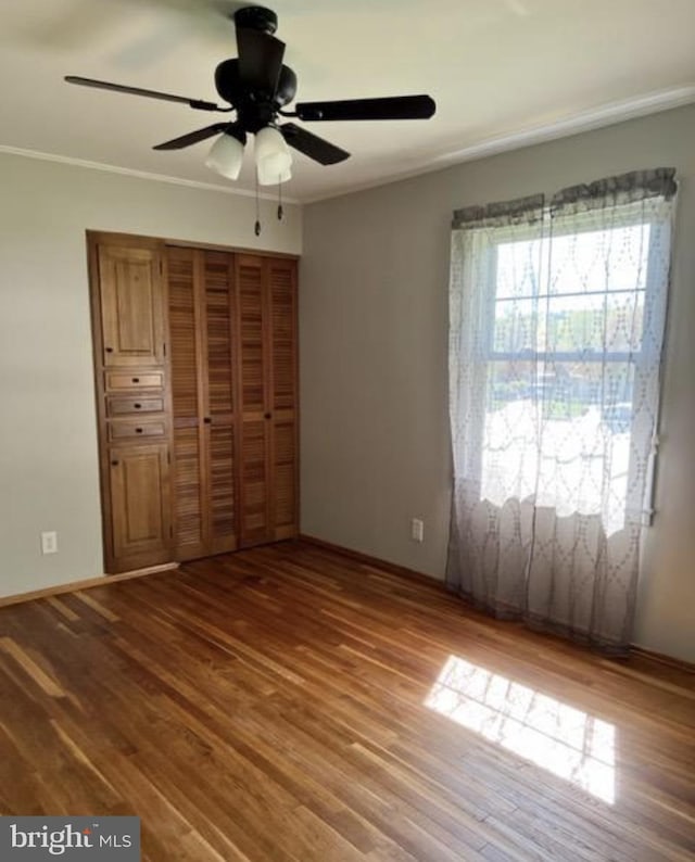 230 Eisenhower Dr, Orwigsburg, PA 17961 - unfurnished bedroom with wood finished floors, a closet, baseboards, crown molding, and a ceiling fan