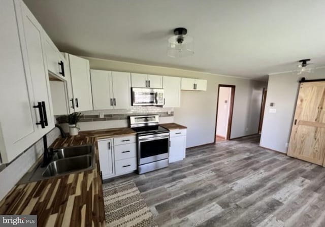 230 Eisenhower Dr, Orwigsburg, PA 17961 - kitchen with appliances with stainless steel finishes, a sink, wood counters, tasteful backsplash, and white cabinets